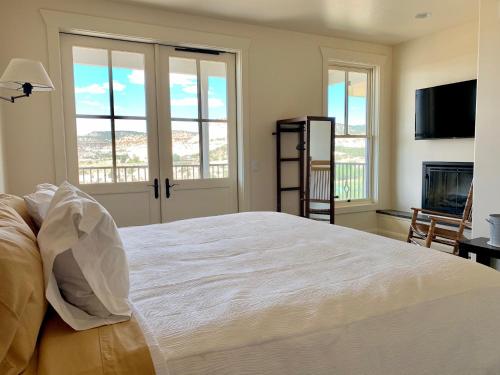 a bedroom with a large white bed and a fireplace at Annie's Place Bed & Breakfast in Boulder Town