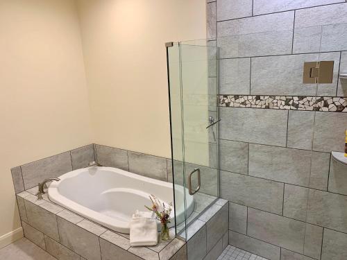 a bathroom with a tub and a glass shower at Annie's Place Bed & Breakfast in Boulder Town