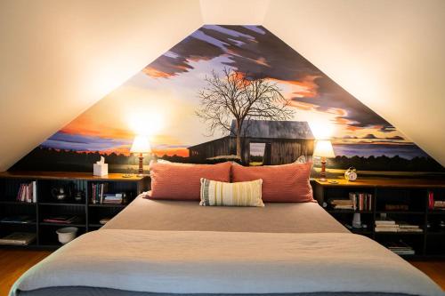a bedroom with a bed with a painting on the wall at Craftsbury Farmhouse in Craftsbury