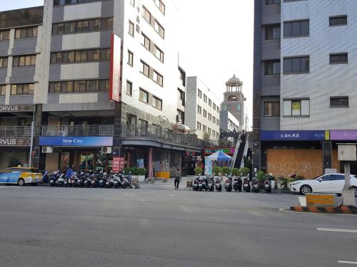 a city street with motorcycles parked in front of tall buildings at 台中一中街格雷熊 in Taichung