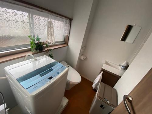 baño pequeño con aseo y ventana en Takemura Building 301, en Tokio