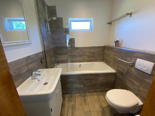 a bathroom with a tub and a toilet and a sink at Landelijk en toch centraal, eigen keuken en veel privacy in Bleiswijk