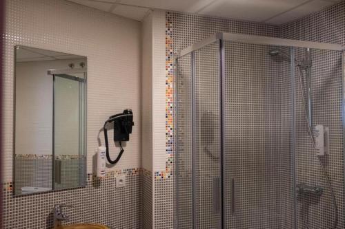 een badkamer met een douche en een telefoon aan de muur bij Spa Suites Odeón in Narón