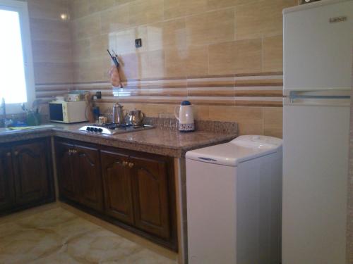 a kitchen with a sink and a refrigerator at Magnifique Appartement Plage Saidia in Saidia 