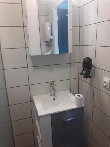 une salle de bain avec un lavabo et un miroir dans l'établissement studio exposé plein sud vu sur le port de plaisance, à Perros-Guirec