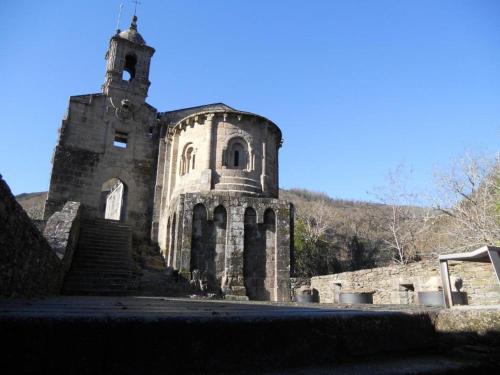 an old stone building with a tower on a hill at Spa Suites Odeón in Narón