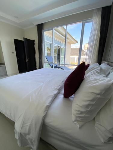a large white bed with two pillows and a window at Marseillia Hills in Puncak