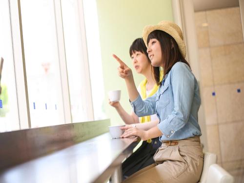 two women sitting at a counter with a cup of coffee at Meitetsu Inn Nagoya Nishiki in Nagoya