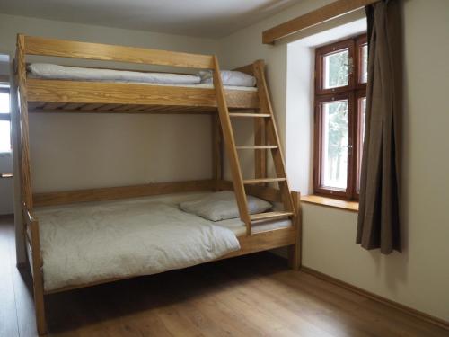 a room with two bunk beds and a window at Draslovanka in Bedřichov