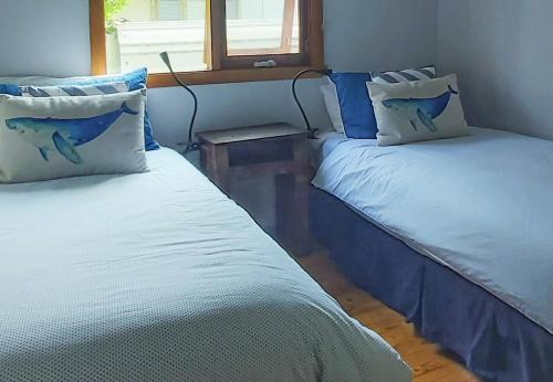 two beds sitting next to each other in a room at 'Point Break' Your Waterfront Break at the Point in Sanctuary Point