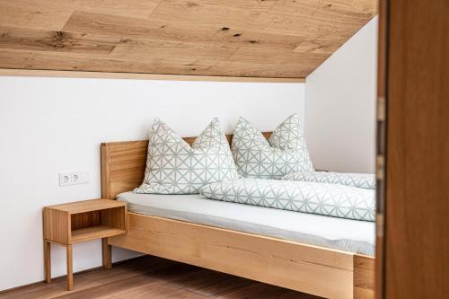 a bed with white pillows on it in a room at Haus Moosbrugger in Mellau