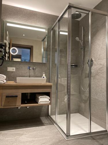 a bathroom with a glass shower and a sink at Pension Eberharter in Mayrhofen