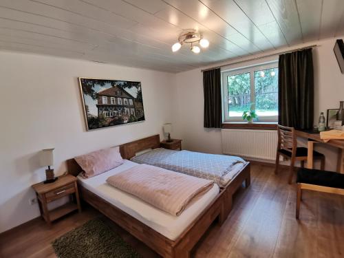 Schlafzimmer mit einem Bett, einem Schreibtisch und einem Fenster in der Unterkunft Bleckmanns Hof in Werne an der Lippe
