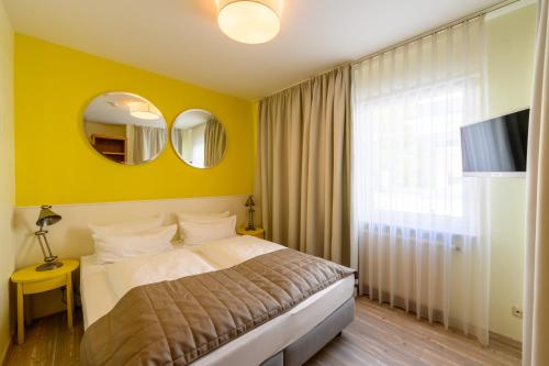 ein Schlafzimmer mit einem Bett und einer gelben Wand in der Unterkunft Hotel Glockengasse in Köln