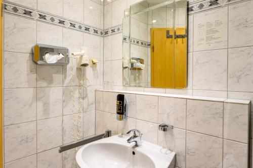 Hotel Glockengasse في كولونيا: حمام أبيض مع حوض ومرآة