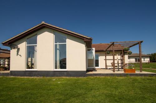 a white house with large windows and a yard at Stoneleigh Village in Sidmouth