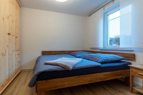 um quarto com uma cama com lençóis azuis e uma janela em Saale Unstrut Ferienwohnung II em Naumburg