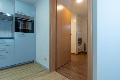 uma cozinha com armários brancos e uma porta de madeira em Saale Unstrut Ferienwohnung II em Naumburg