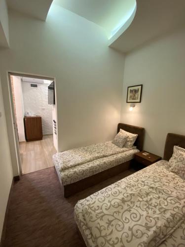 a hotel room with two beds and a hallway at Apartmani Diksi 2 CENTAR in Zrenjanin