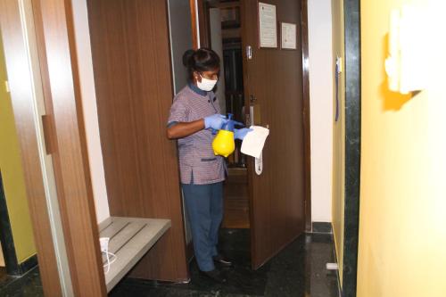 a woman in a mask using a yellow object in a elevator at Capitol Hill in Rānchī