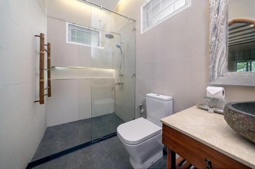 a bathroom with a toilet and a glass shower at Samed Villa Resort in Ko Samed
