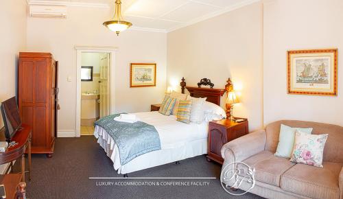 a bedroom with a bed and a chair and a couch at Roseland House in Durban