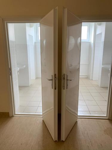 two white doors in a room with a bathroom at Loksa Hostel in Loksa