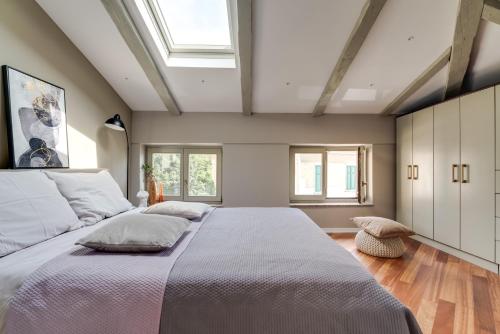 sypialnia z dużym łóżkiem i oknem dachowym w obiekcie Luxury Apartment Regina w mieście Opatija