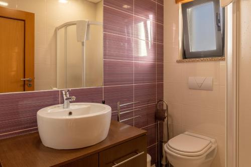 a bathroom with a sink and a toilet at Apartamento 7 Mares com 2 Quartos in Sagres