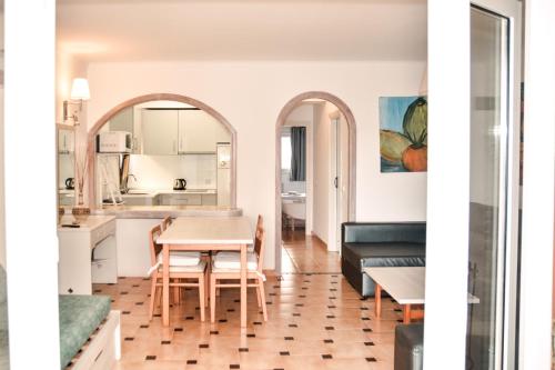 a kitchen and living room with a table and chairs at Rosamar Holidays Apartments in Cala Ratjada