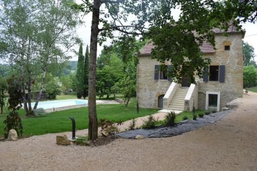 una casa de piedra con una piscina frente a ella en Domaine du BOURNAT, en Camboulit