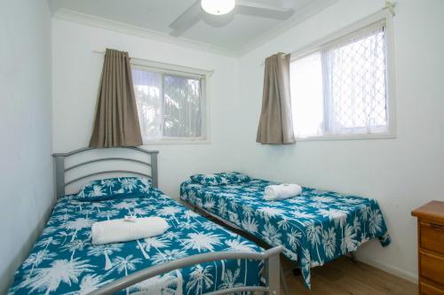 a bedroom with two beds and two windows at Bundaberg Park Village in Bundaberg