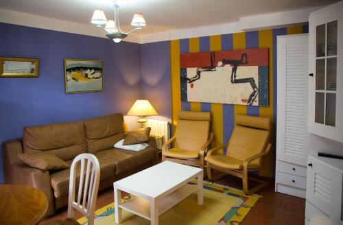 a living room with a couch and a table and chairs at Apartamentos Alquitara in Potes