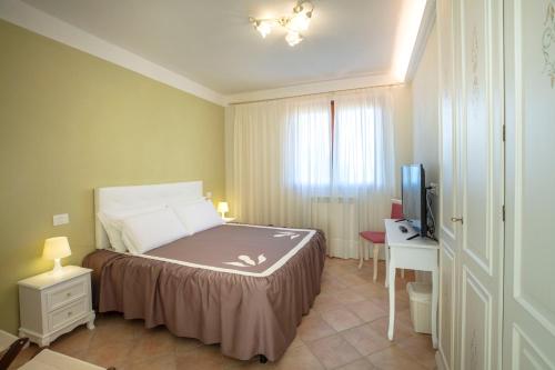 a bedroom with a bed and a desk and a television at La Dimora dei Tribbi in Rapolano Terme