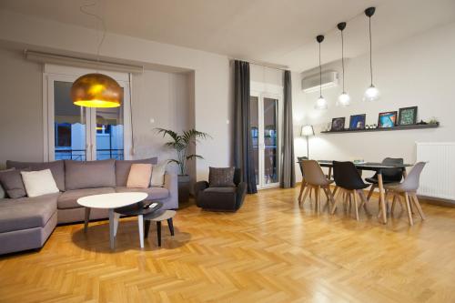 a living room with a couch and a table and chairs at Acropolis View Penthouse N in Athens