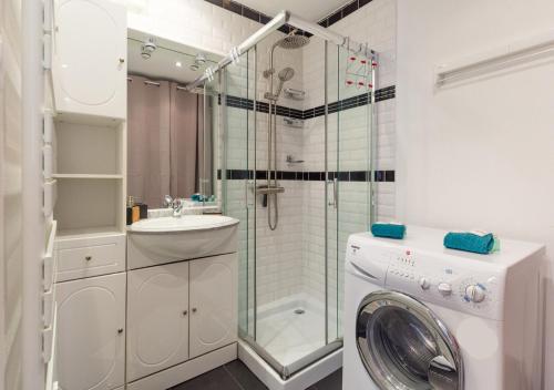 een badkamer met een douche en een wasmachine bij Grünewald Colmar - Studio 2 pers - Parking in Colmar