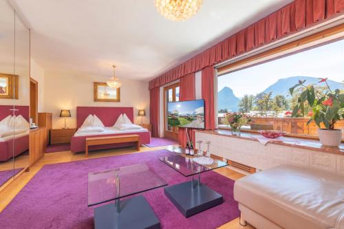 - un salon avec un canapé et une grande fenêtre dans l'établissement Hotel Furian, à Sankt Wolfgang im Salzkammergut