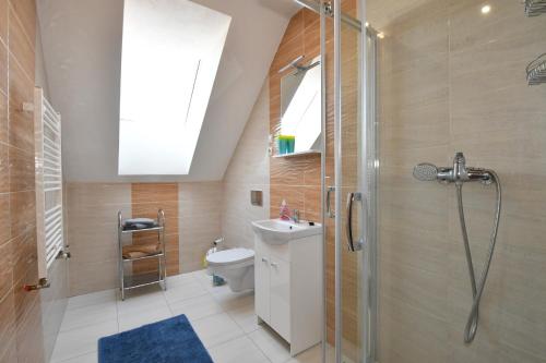 een badkamer met een douche, een toilet en een wastafel bij Apartmany Kenka in Spišská Stará Ves