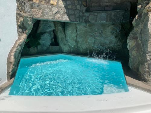 una piscina d'acqua in una cascata in bagno di Rock House Villa a Ischia