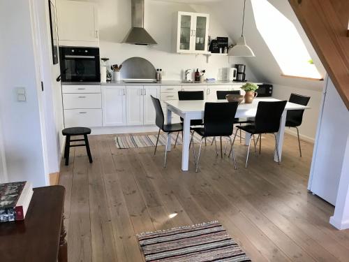 kuchnia z białym stołem i krzesłami w obiekcie Tåning Gl. Mejeri w mieście Skanderborg