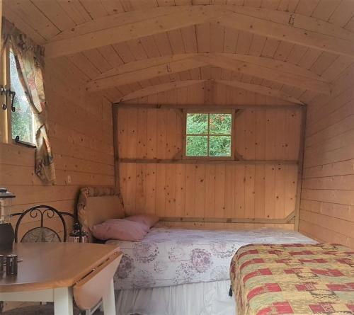 a bedroom with a bed in a wooden room at Rum Bridge Gypsy 'Rose' in Sudbury