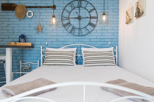 a blue bedroom with a white bed and a clock at Apartment Alida in Krk