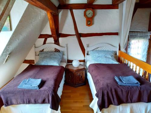 2 camas en una habitación con ático en Ferienhaus Marré - mit Grill, Feuerstelle und Gartensauna en Waldbrunn