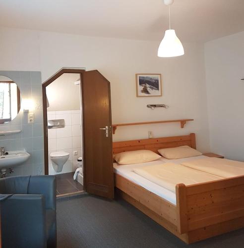 a bedroom with a bed and a bathroom with a sink at Villa Steiermark in Bad Reichenhall