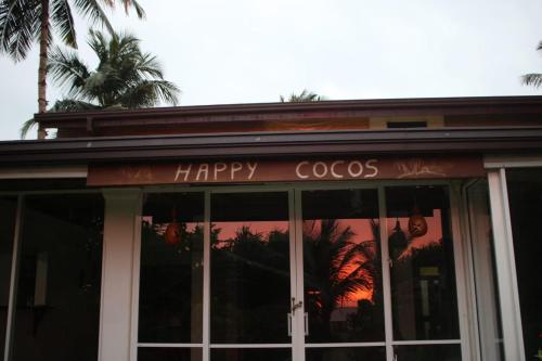 un cartel feliz de cocos en la parte delantera de un restaurante en Happy Cocos Beach House, en Waskaduwa