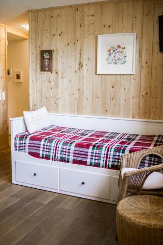 a white bed in a room with wooden walls at Zur grossen Tanne in Bühl