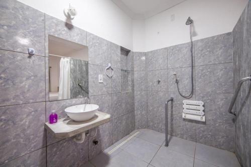 a bathroom with a sink and a shower at Luxury Flats Ambiente Cristão in Fortaleza