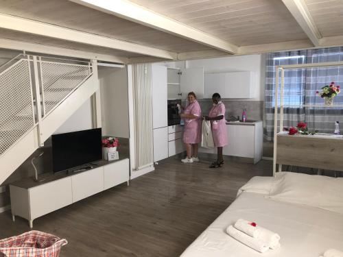 ボローニャにあるLe Suite di Luna Rossellaの二人の女性が部屋に立つピンクの衣装