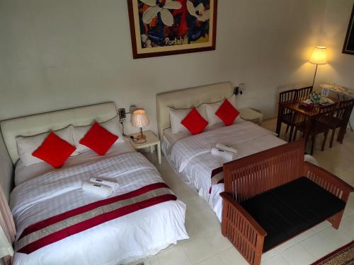 a hotel room with two beds and two lamps at Kurau Inn Farmstay in Kuala Kurau