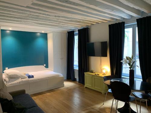 une chambre avec un lit et un mur bleu dans l'établissement LOUVRE ST GERMAIN Rue VERNEUIL, à Paris